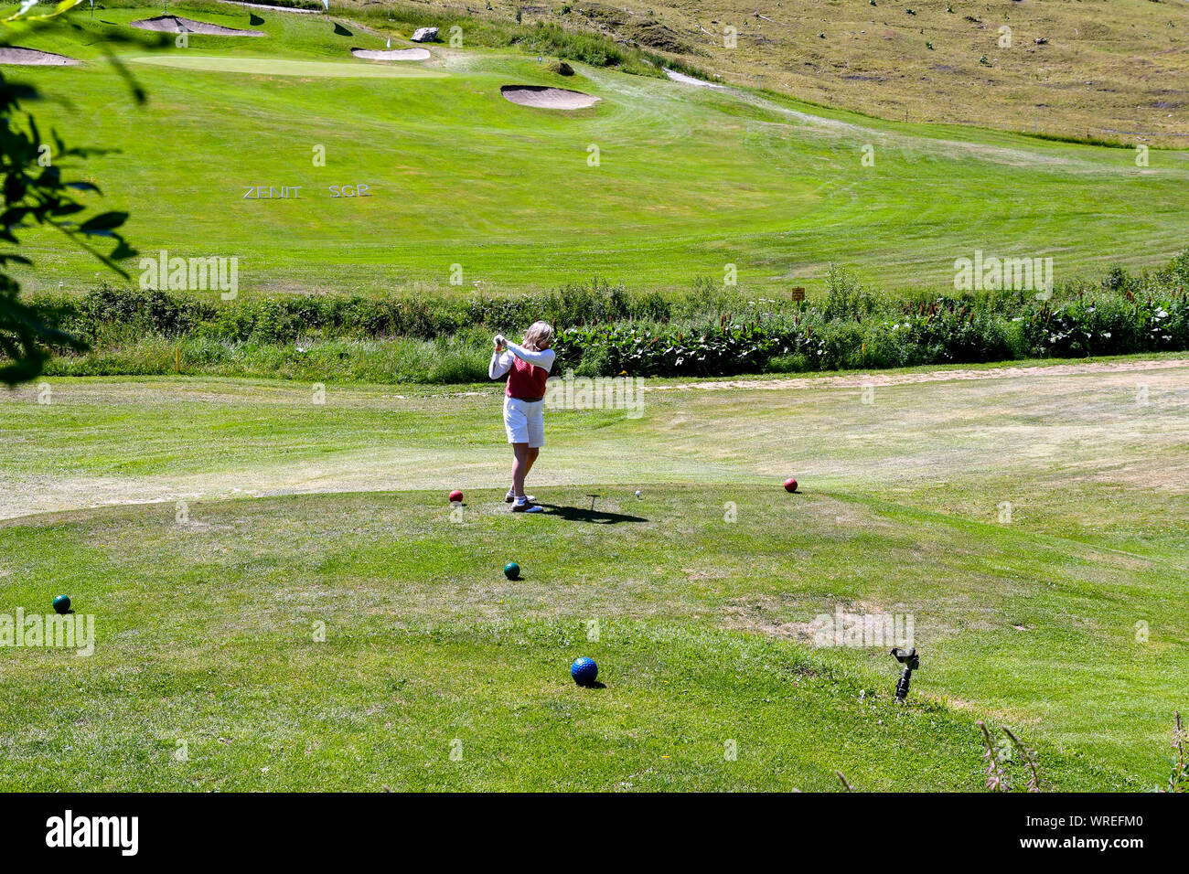 Une femme d'âge moyen jouer au golf au Club de Golf de Courmayeur et Grandes Jorasses de Val Ferret, une vallée au pied du massif du Mont Blanc, Alpes, Italie Banque D'Images