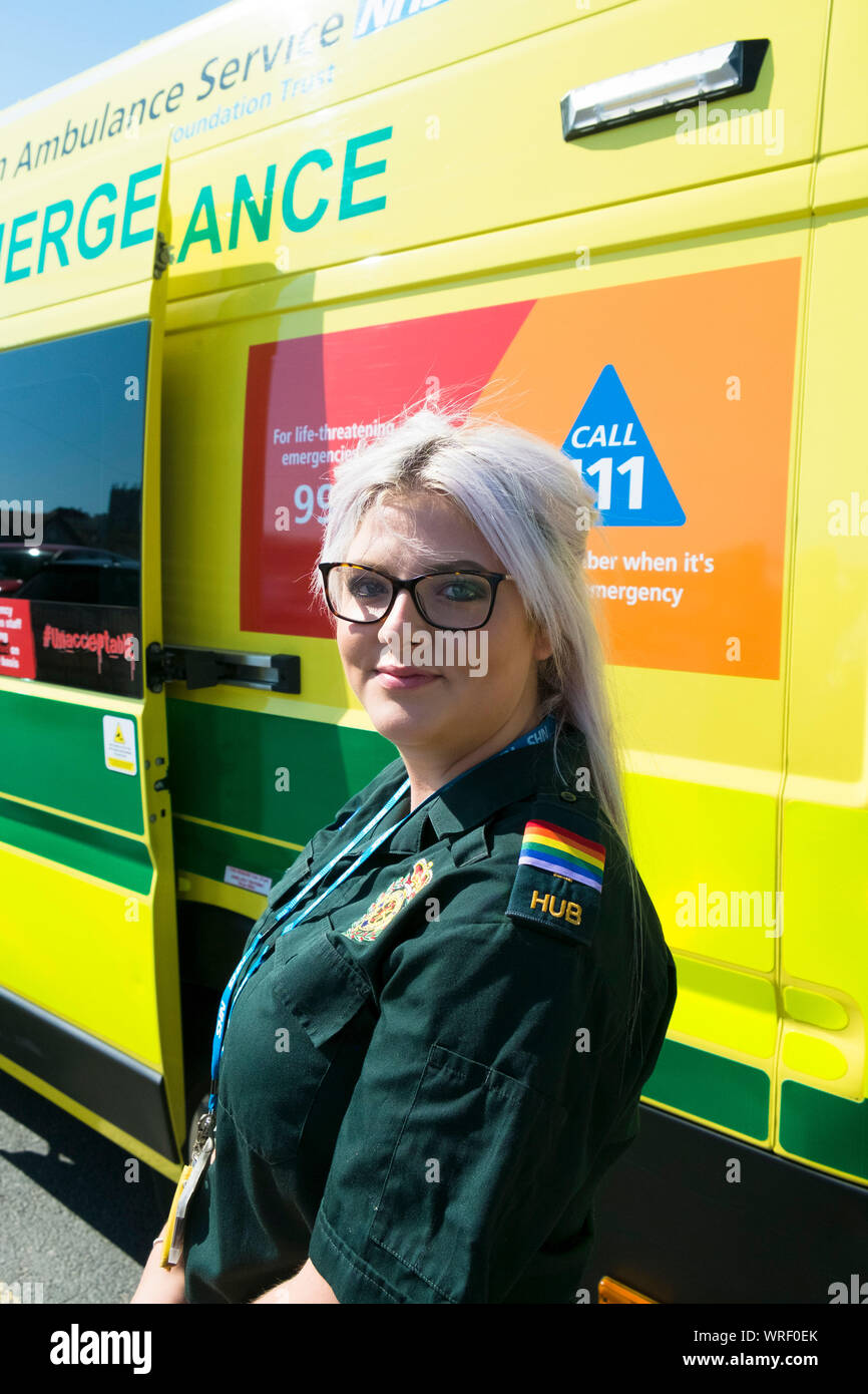 Un membre d'équipage d'Ambulance NHS portant les épaulettes de la Gay Pride, debout devant une ambulance au Cornwall Gay Pride Parade dans le centre-ville de Newquay. Banque D'Images