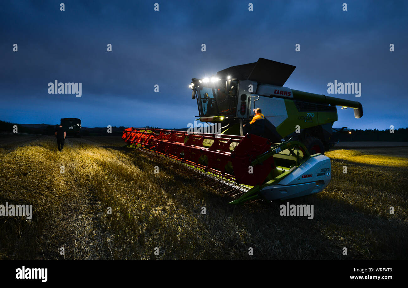 Farmer pour revenir dans sa moissonneuse-batteuse, après avoir discuté de l'un de ses travailleurs le prochain champ à moissonner. Banque D'Images
