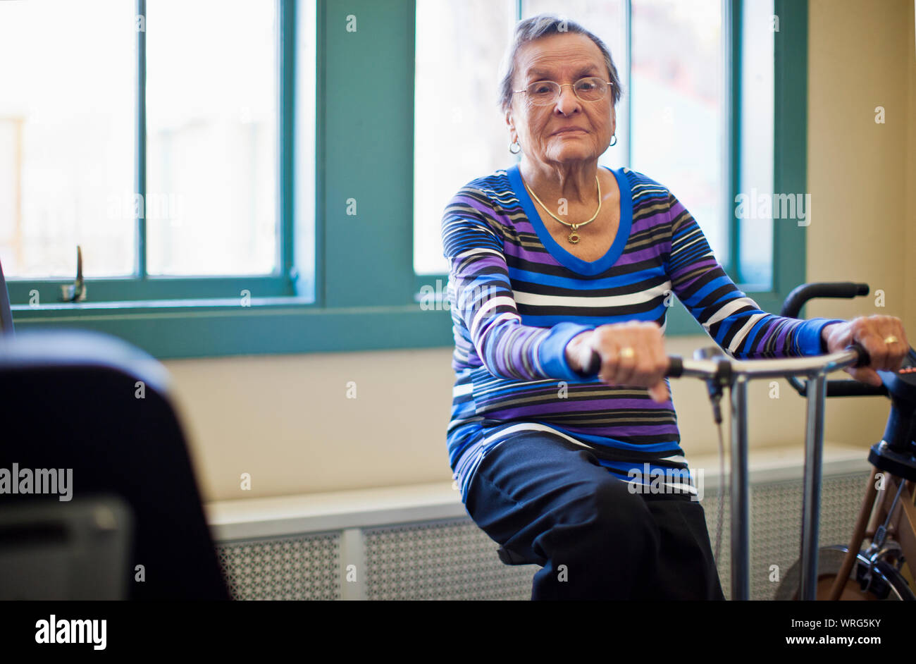 Portrait of a senior woman de la bicyclette d'exercice dans la salle de sport. Banque D'Images