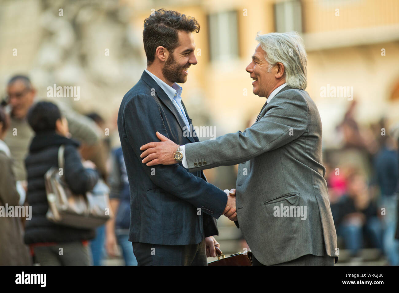 Mature businessman a une rencontre fortuite avec un jeune collègue, alors qu'ils sont dans la ville. Banque D'Images