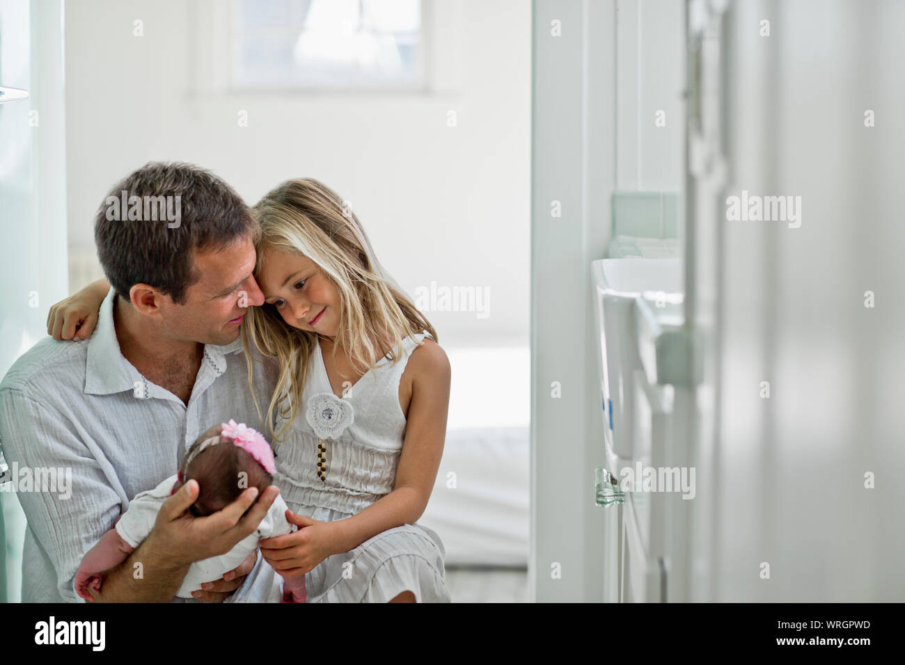 Les nouveaux parents souriant fièrement en regardant leur bébé nouveau-né fille. Banque D'Images