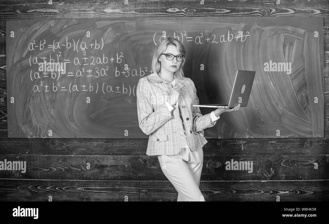 Femme blonde enseignant avec ordinateur portable moderne tableau internet surf arrière-plan. L'innovation de l'école. Concept de formation à distance. L'enseignant détient dame portent des lunettes pour ordinateur portable Internet surf. Banque D'Images