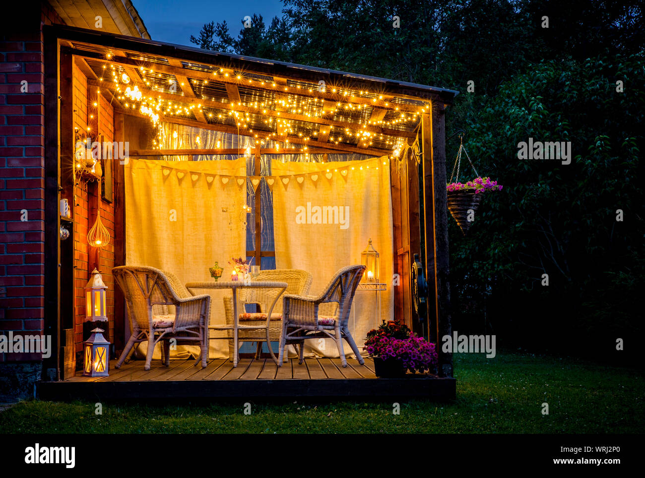 Vue sur piscine agréable terrasse avec table et chaises, éclairage blanc très romantique, lanternes, bougies, lampes led string party et ampoules Banque D'Images