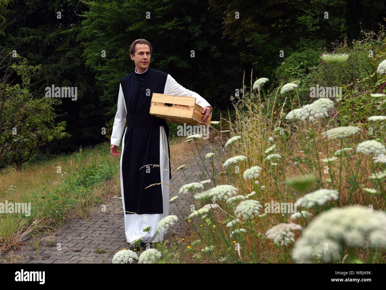 15 juillet 2019, Bochum, Rhénanie du Nord-Westphalie : Père Justinus promenades dans le jardin du monastère cistercien dans le district de Stiepel. Dans sa propre production, il produit un haut pourcentage de gin et l'appelle "onatic Dry Gin'. Les herbes qu'il a besoin sont plantées et récoltées dans le jardin du monastère. Il obtient le genévrier de Toscane et le grain d'où l'alcool est obtenu qu'il obtient de l'abbaye de Heiligenkreuz mère dans la forêt viennoise. Dans le monastère lui-même il n'est pas autorisé à brûler de gin, parce qu'il n'a pas de droits de distillation. Pour ce qu'il conduit à un producteur nearb Banque D'Images