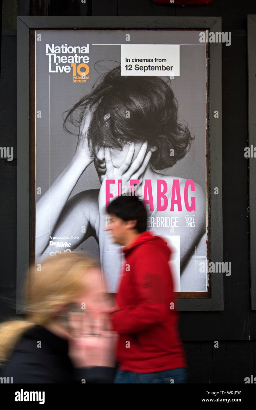 Les piétons (with motion blur) à pied par une publicité pour Fleabag avec Phoebe Waller-Bridge vit au Théâtre National et dans les cinémas. Banque D'Images