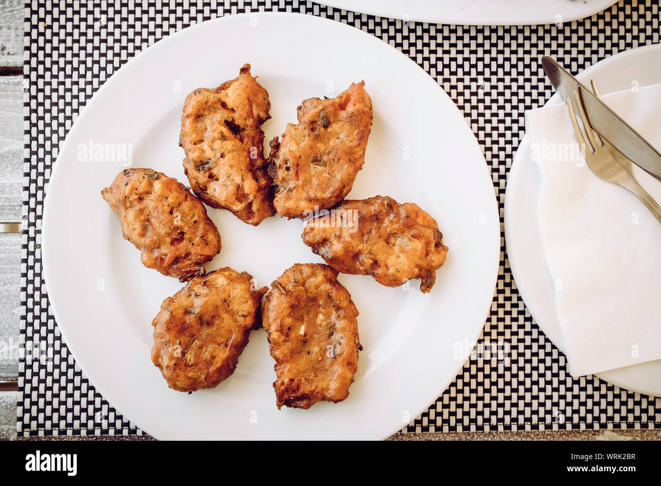 Vue du haut vers le bas de la nourriture grecque : Tomate Tomate Santorini balls ( beignets, tomatokeftedes) en Grèce, Santorini Island tavern table. Banque D'Images