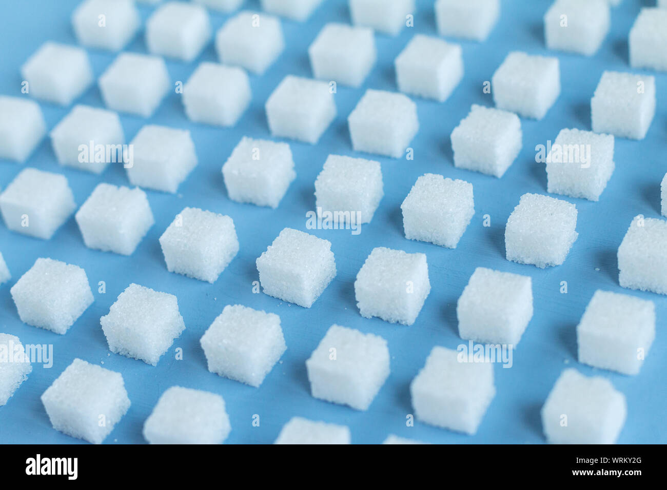 Motif répétitif avec des morceaux de sucre, fond bleu, papier peint. selective focus Banque D'Images