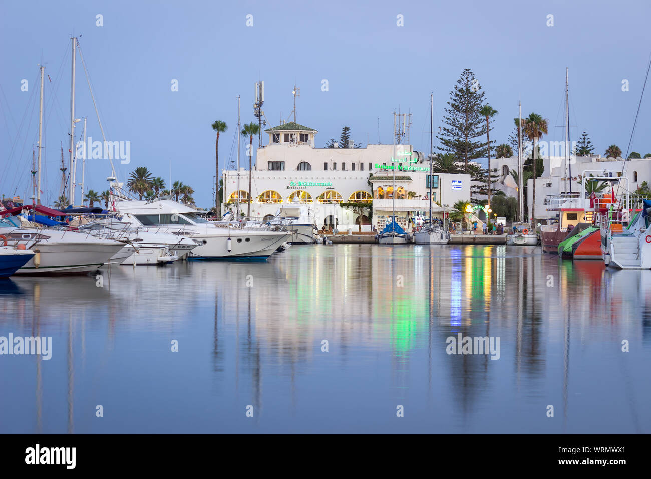 Heure bleue à Marina Port El Kantaoui, de beaux bateaux, yachts et bateaux stationnés dans la mer, restaurants et boutiques de cadeaux Banque D'Images