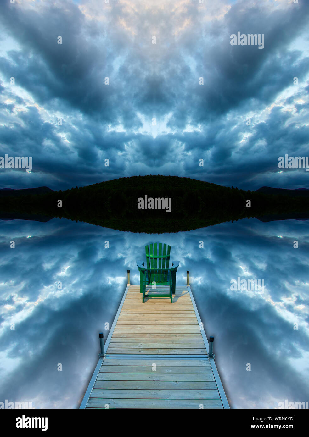 Image manipulée numériquement d'une chaise adirondack assis sur un quai avec miroir de nuages orageux et un fond de montagne. Banque D'Images
