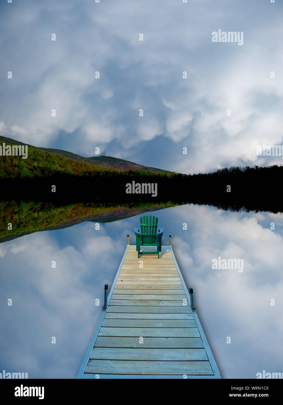 Image manipulée numériquement d'une chaise adirondack assis sur le bout d'un quai dans un nuage reflété lake. Banque D'Images