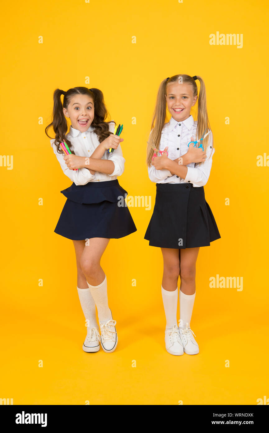 Faites-le vous-même surprise. Heureux les élèves ou les jeunes apprenants. Cute pupils holding outils créatifs sur fond jaune. Les petits élèves de se préparer pour les arts et d'artisanat. Peu d'élèves de l'école. Banque D'Images