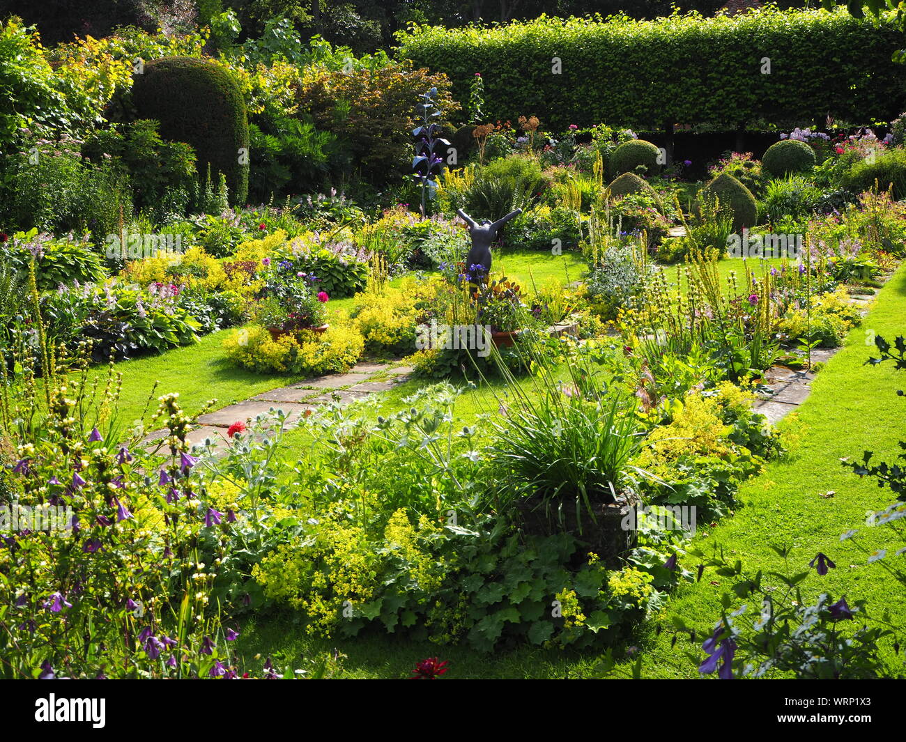 Chenies Manor jardin en contrebas avec des sculptures de Jenny Pickford et Alan Biggs.plantes vertes luxuriantes au début de l'été . Banque D'Images