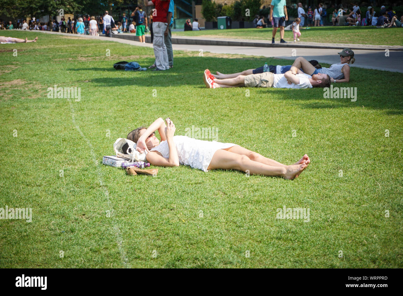 Une femme est vu de soleil pendant une journée chaude sur la rive sud, au centre de Londres. Photo par Ioannis Alexopoulos / Alamy. Banque D'Images