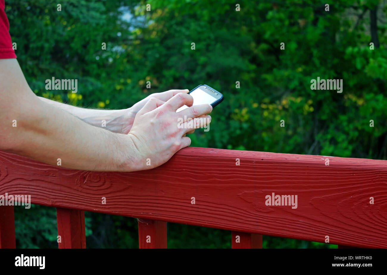 Mâle adulte phone sur le pont - closeup of hands Banque D'Images