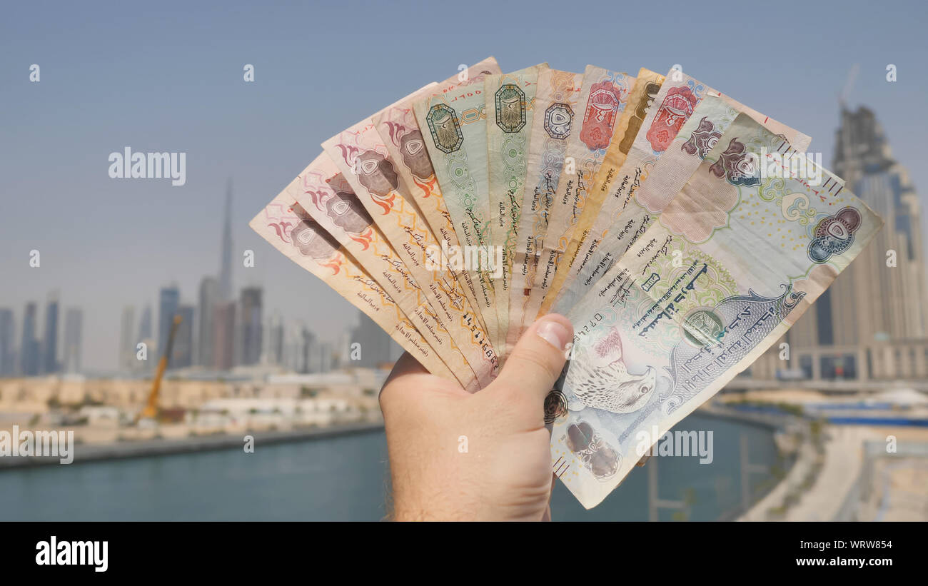 Un homme tient dans sa main l'argent de l'État des Émirats arabes unis. Part de près. Banque D'Images