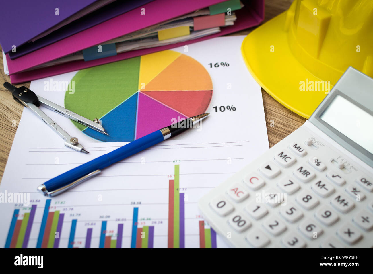 Finances graphique avec stylo, calculatrice et casque de construction sur la table, de l'administration et des finances concept. Banque D'Images