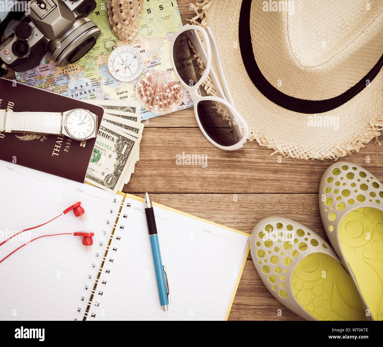 Concept de voyage avec un appareil photo numérique, chapeau de paille, lunettes de soleil, carte du monde, boussole, passeport, argent, bracelet, écouteurs, chaussures, bloc-notes, un stylo et seashel Banque D'Images