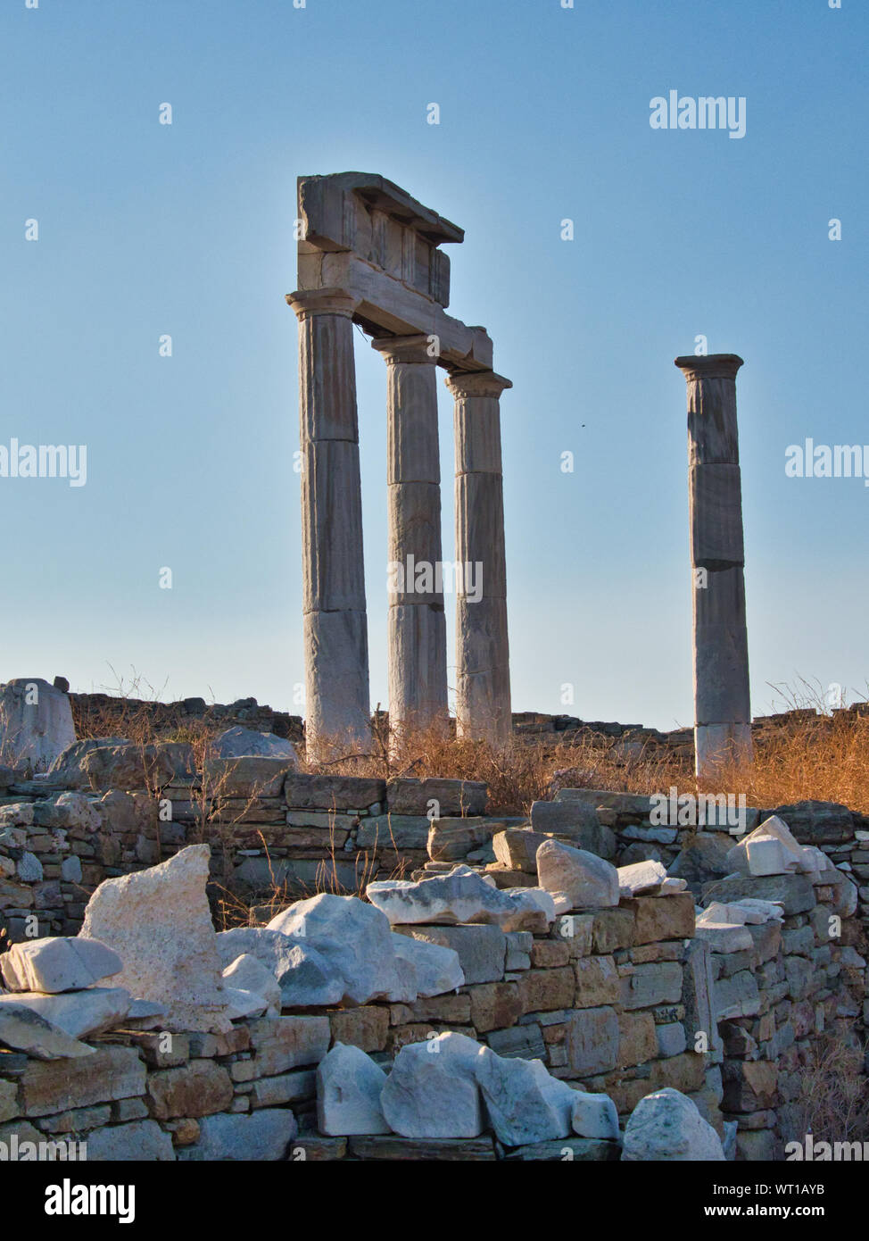 Piliers classiques et minable mur de pierre est resté de l'ancienne ville sur Delos en Grèce contre le fond de ciel bleu Banque D'Images