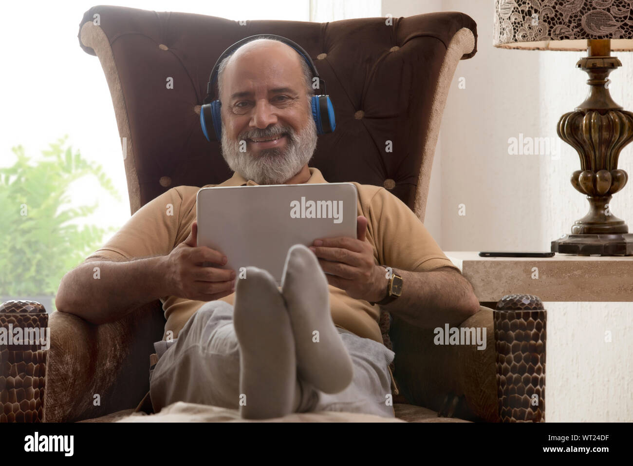 Senior man relaxing while listening music Banque D'Images