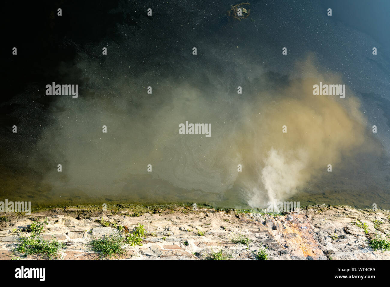 Vue détaillée d'eaux usées et sale de l'eau s'écoule dans une rivière propre Banque D'Images