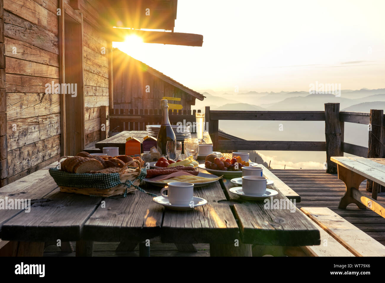 Table de petit déjeuner en terrasse patio rustique en bois, d'une hutte Hutte in Tirol alm au lever du soleil Banque D'Images