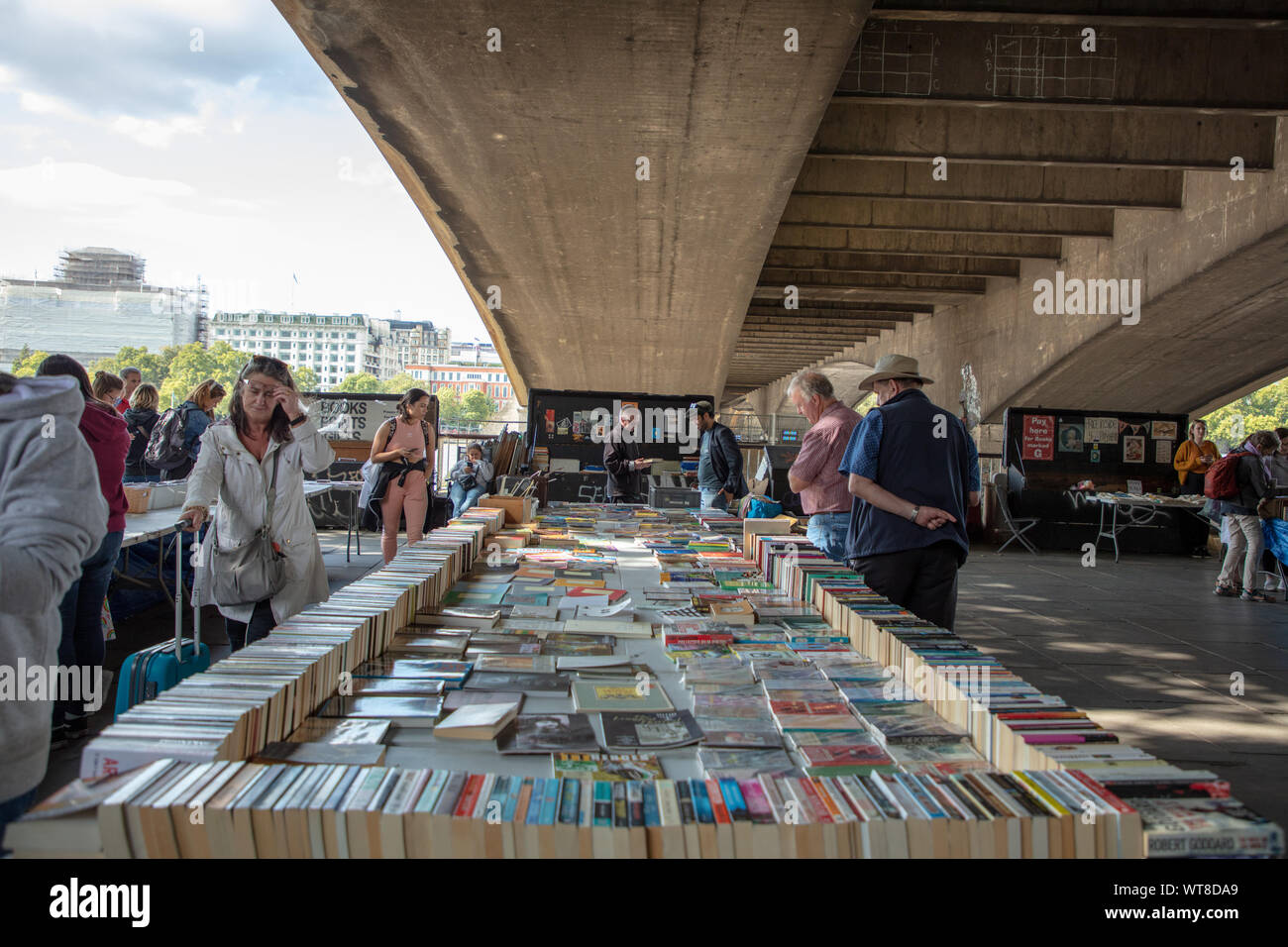 Les gens parcourant et achat de livres à vendre sur la rive sud du marché du livre en vertu de Waterloo Bridge, Londres. Banque D'Images