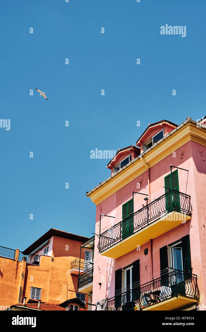 Maison de vacances d'été - maisons peintes de couleurs vives et de mouettes sur le front d'Imperia sur la Riviera Italienne en été. Banque D'Images