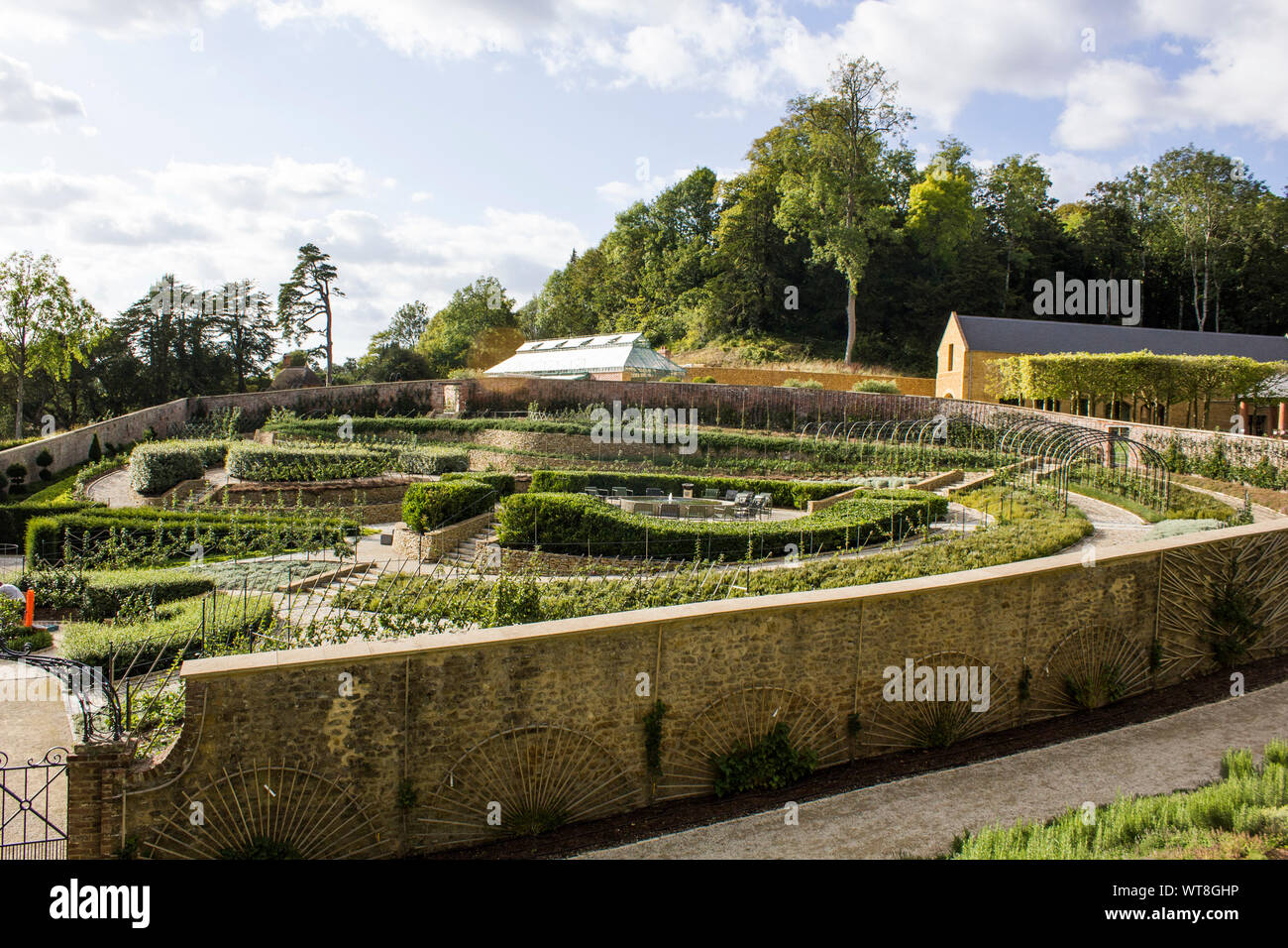 Un beau jardin clos avec un arrangement intéressant des pommiers et des plantes à. Le Triton dans le Somerset. Banque D'Images