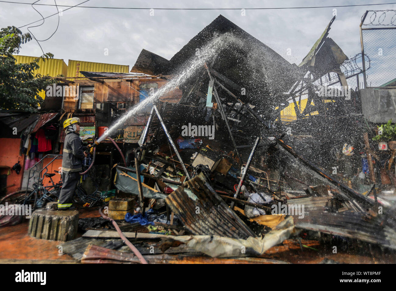 Manille, Philippines. Sep 11, 2019. Un pompier essaie d'éteindre un incendie dans un quartier résidentiel à Manille, Philippines, le 11 septembre 2019. Trois personnes sont mortes, dont deux enfants de quatre et cinq ans, et deux autres blessées dans un incendie qui a frappé une zone résidentielle de la capitale des Philippines, Manille, le mercredi, le bureau local de la protection contre les incendies a dit. Credit : Rouelle Umali/Xinhua/Alamy Live News Banque D'Images