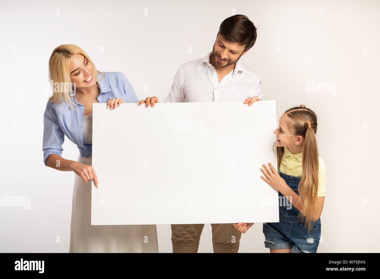 Holding de la famille et à la recherche à bord avec Copyspace dans Studio Banque D'Images