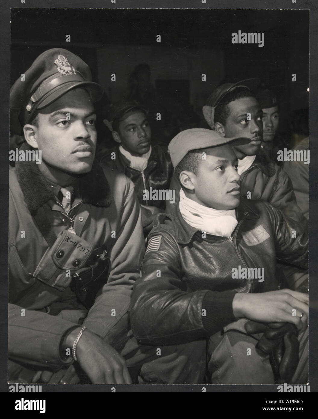 [Les membres de la 332e Fighter Group assistant à une réunion d'information dans Ramitelli, Italie, Mars, 1945] ; la photographie montre les membres de la 332ème, de gauche à droite : Robert W. Williams, Ottumwa, IA, classe 44-E ; cuir (cap) William H., Holloman III, Saint Louis, Mo., classe 44- ? ; (casquette) Ronald W. Reeves, Washington, D.C., classe 44-G ; cuir (cap) Christopher W. Newman, Saint Louis, MO, classe 43-I ; vol (cap) Walter M. Downs, New Orleans, LA, classe 43-B. (Source : notes du photographe Tuskegee Airmen et 332e Fighter Group pilotes.) ; Banque D'Images