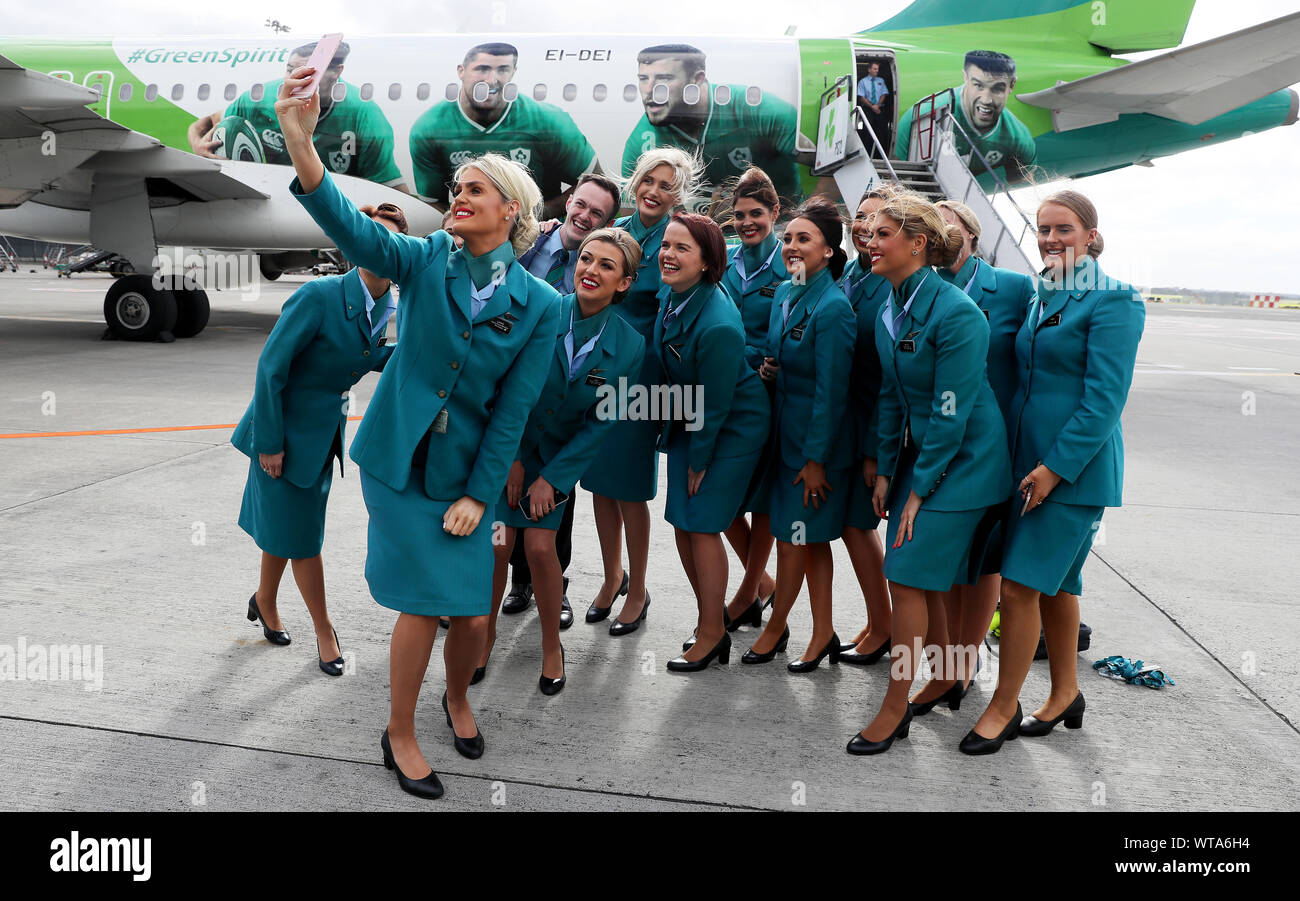 L'équipage de cabine d'Aer Lingus selfies prendre une avec l'avion à l'aéroport de Dublin après l'équipe monte à bord de l'Irlande à partir pour la Coupe du Monde de Rugby 2019 au Japon. Banque D'Images