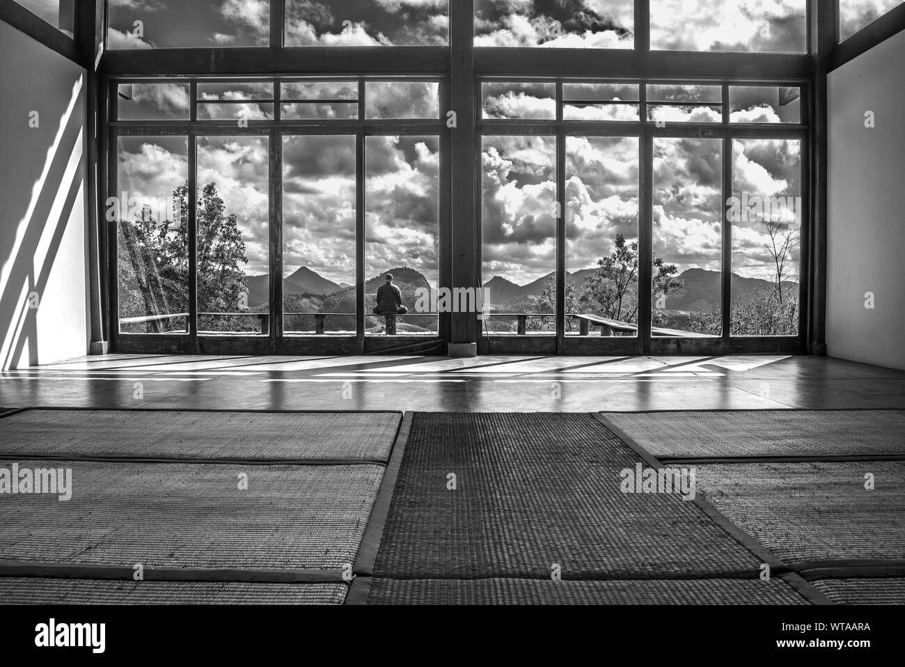 Moine méditant dans une chambre parmi les montagnes Banque D'Images