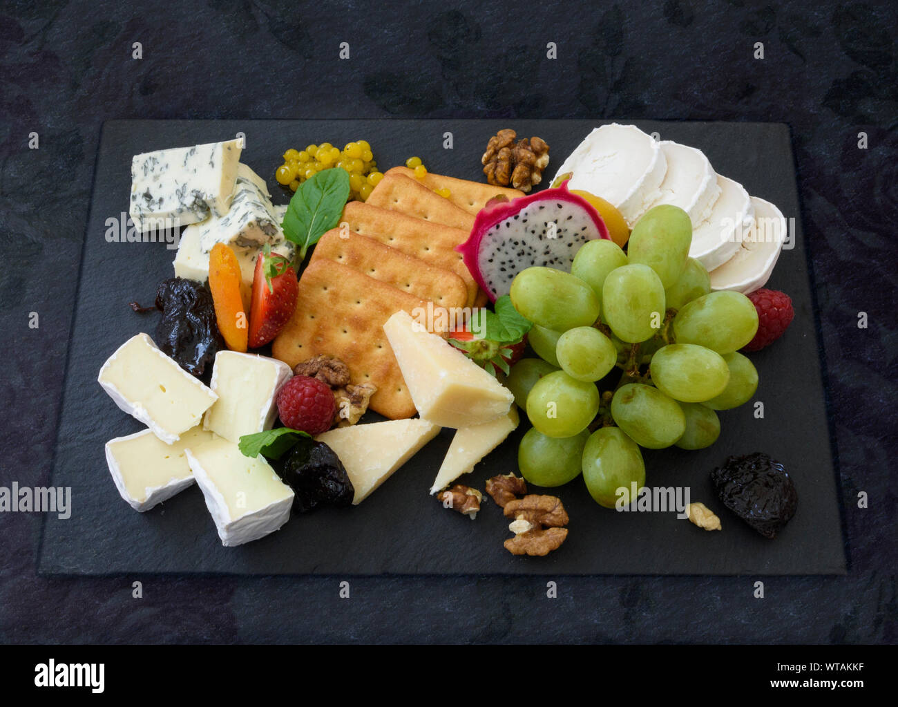 Un repas de fromage et de fruits assortis à un conseil Banque D'Images