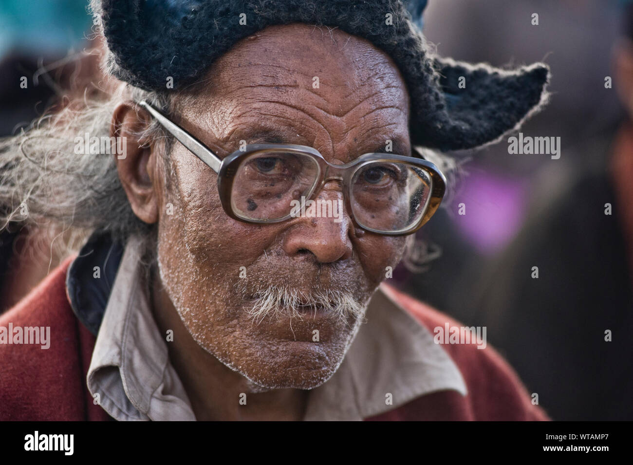 L'homme bouddhiste vieux avec des lunettes et vêtements typiques Banque D'Images