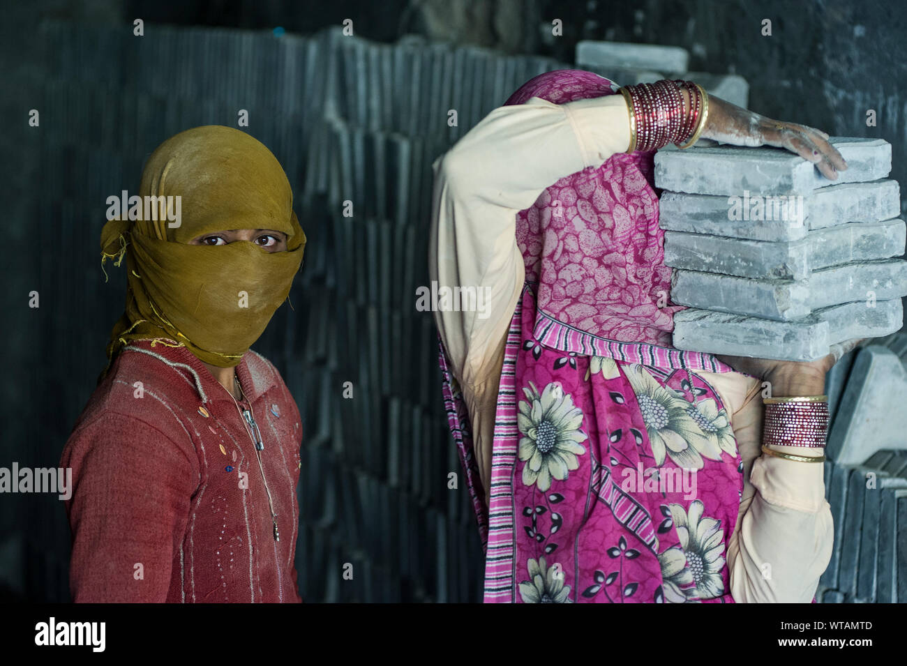 Les travailleurs féminins de porter de lourds matériaux de construction Banque D'Images