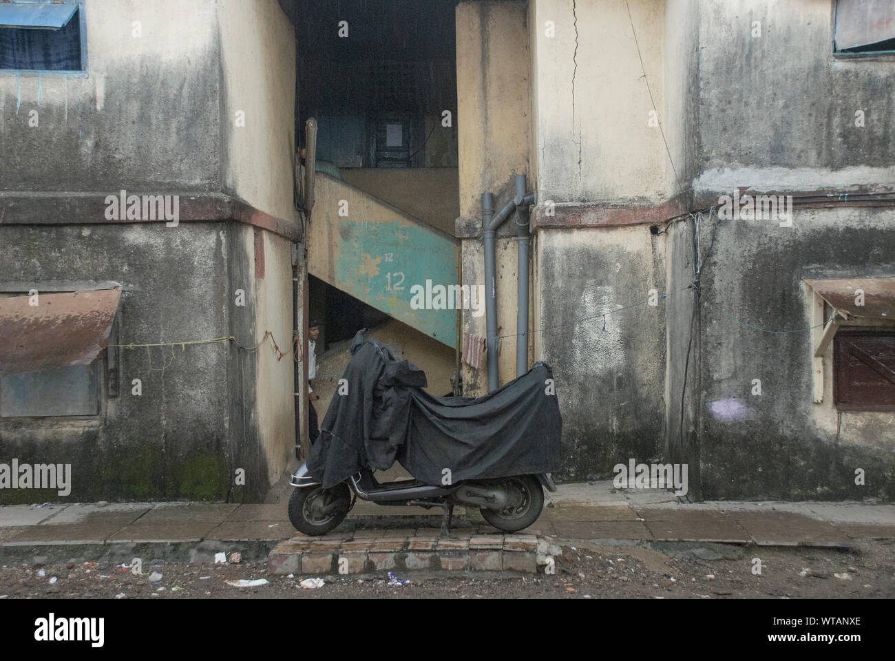 Scooter couvert dans les ruelles de Mumbai Banque D'Images