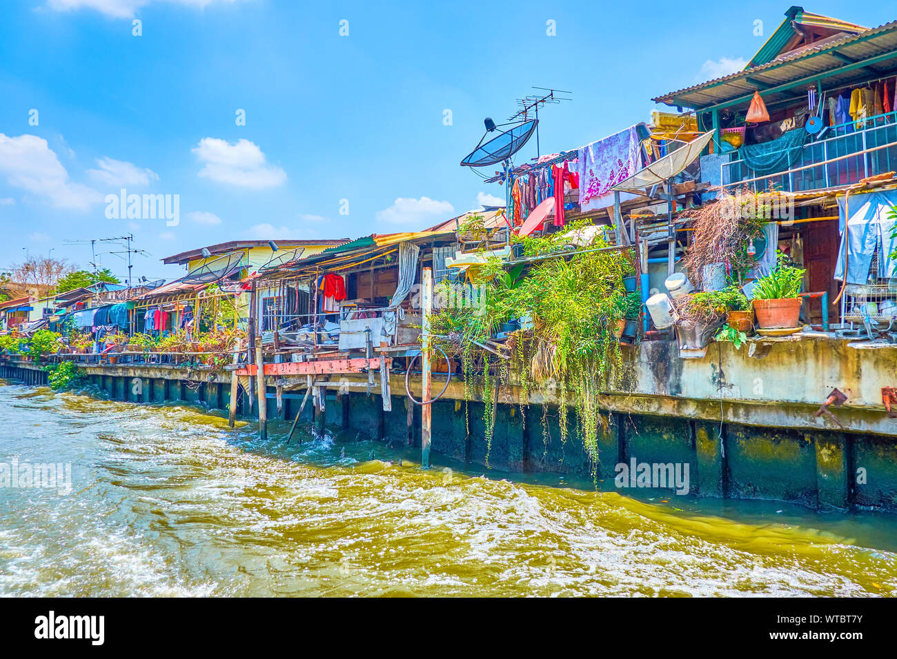 Les pauvres maisons construites sur la rive d'Saensaep khlong est vu depuis le ferry naviguant le long du canal, Bangkok, Thaïlande Banque D'Images