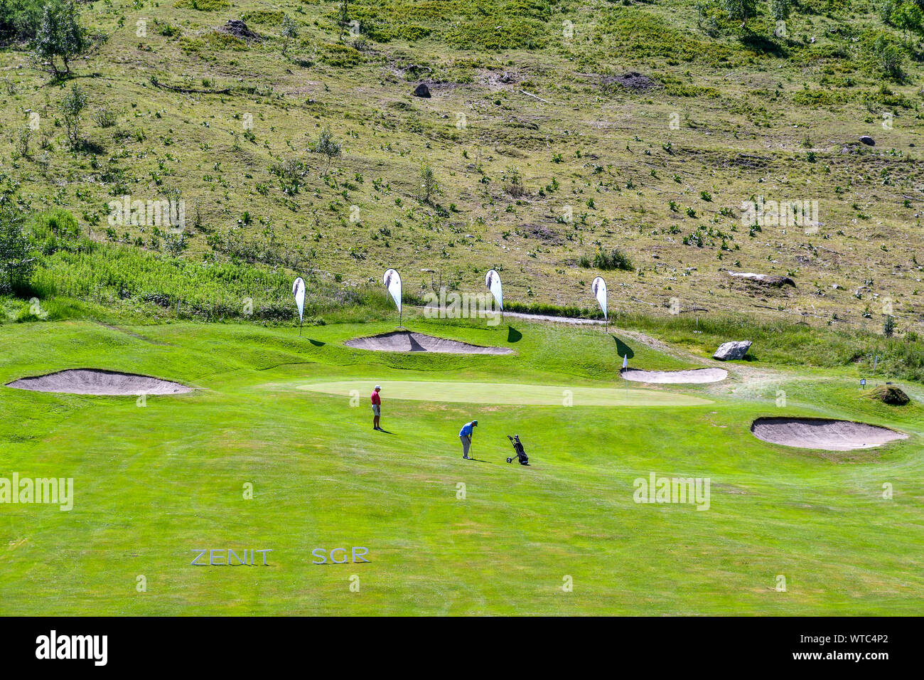 Vue panoramique sur un parcours de golf de montagne avec les golfeurs jouant dans un beau jour d'été, Golf Club Courmayeur, Val Ferret, Courmayeur, vallée d'aoste, Italie Banque D'Images