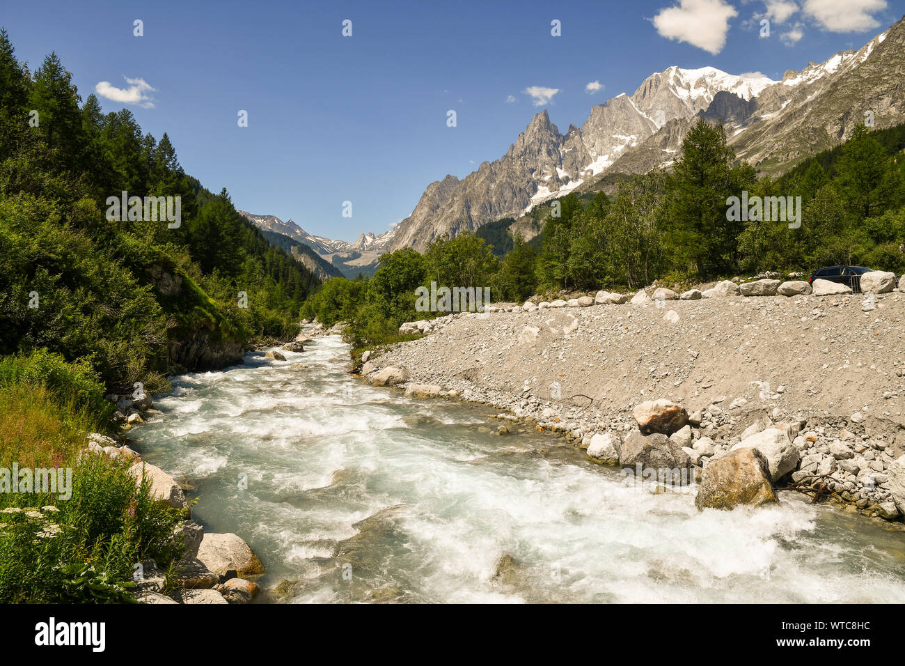 Paysage de montagne avec la rivière Dora dans la vallée Val Ferret avec le Mont Blanc et Aiguille Noire pics dans l'arrière-plan en été, Courmayeur, Italie Banque D'Images