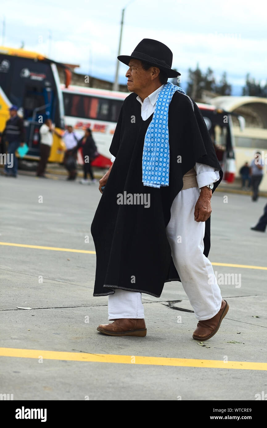 AMBATO, ÉQUATEUR - 12 MAI 2014 : Un homme en vêtements traditionnels balade au terminal de bus le 12 mai 2014 à Ambato, Équateur. Banque D'Images