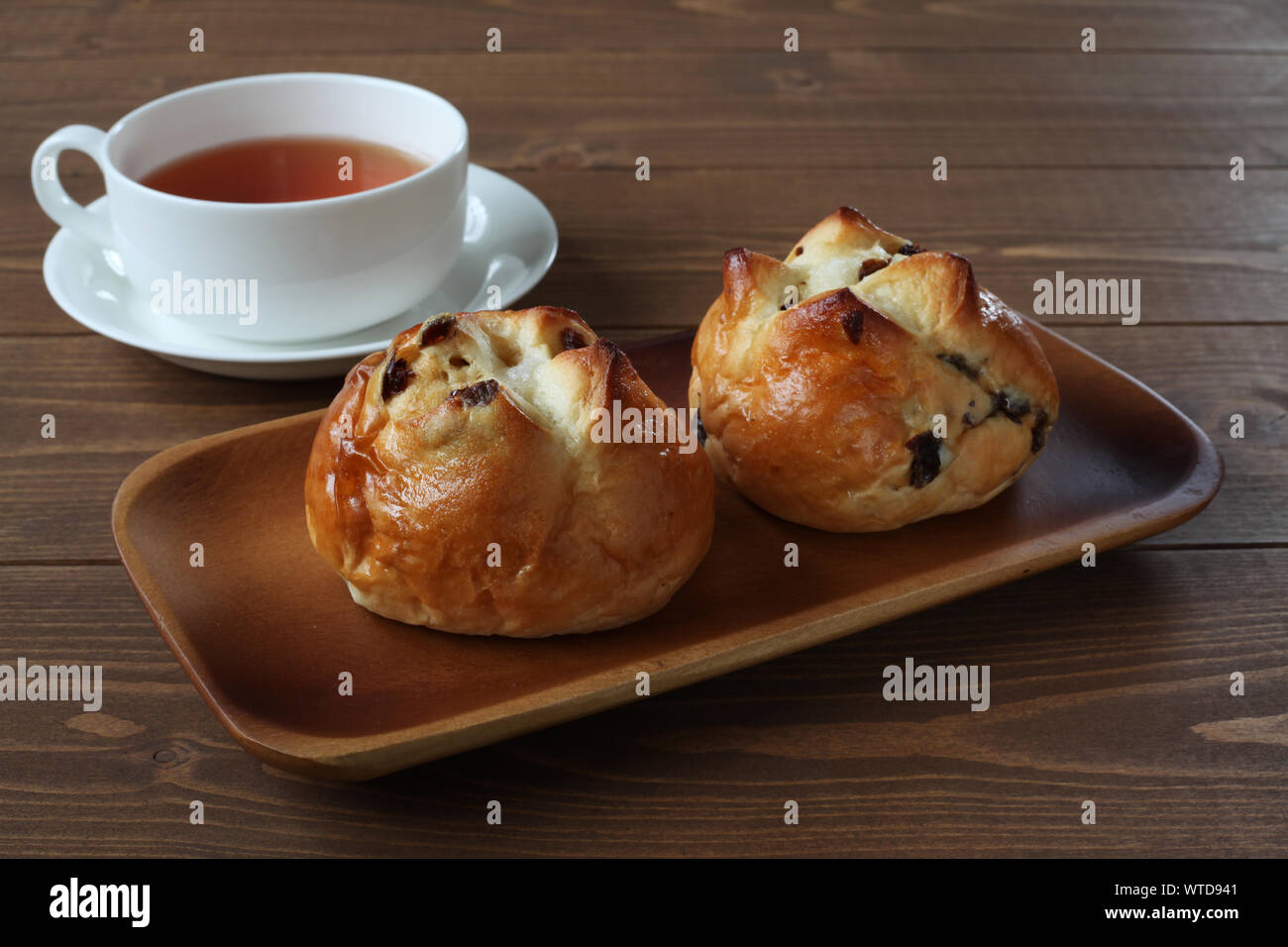 Pain aux raisins avec du thé anglais libre isolé sur le tableau Banque D'Images