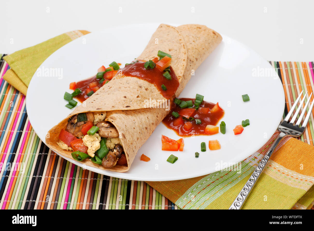 Burrito déjeuner d'œufs brouillés, champignons, oignons, poivrons rouges, et de la salsa. Banque D'Images