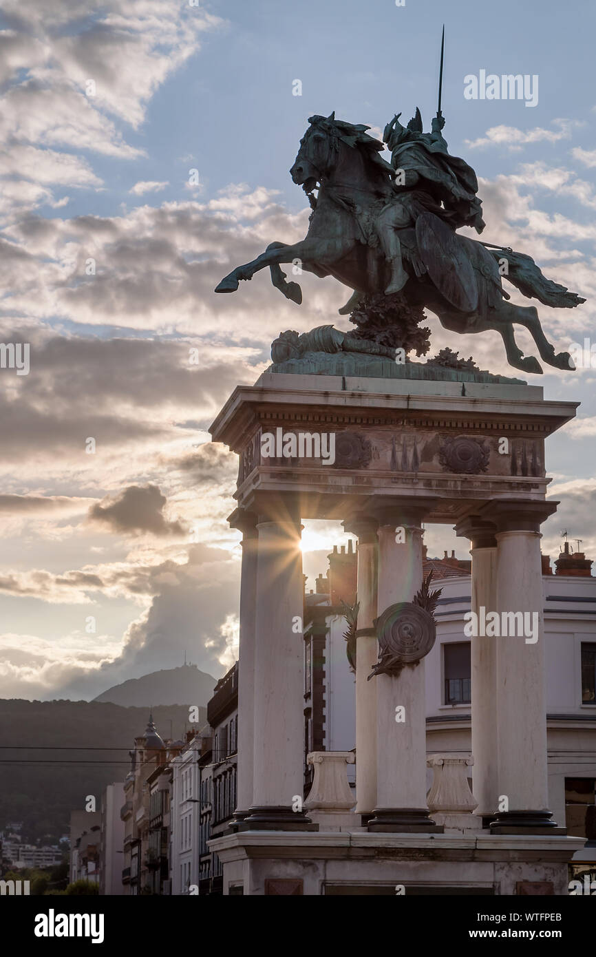 La statue de Vercingétorix sur une place de la ville de Clermont Ferrand en France, de soleil et de dynamitage rayons de soleil derrière elle et volcan Puy de Dome Banque D'Images