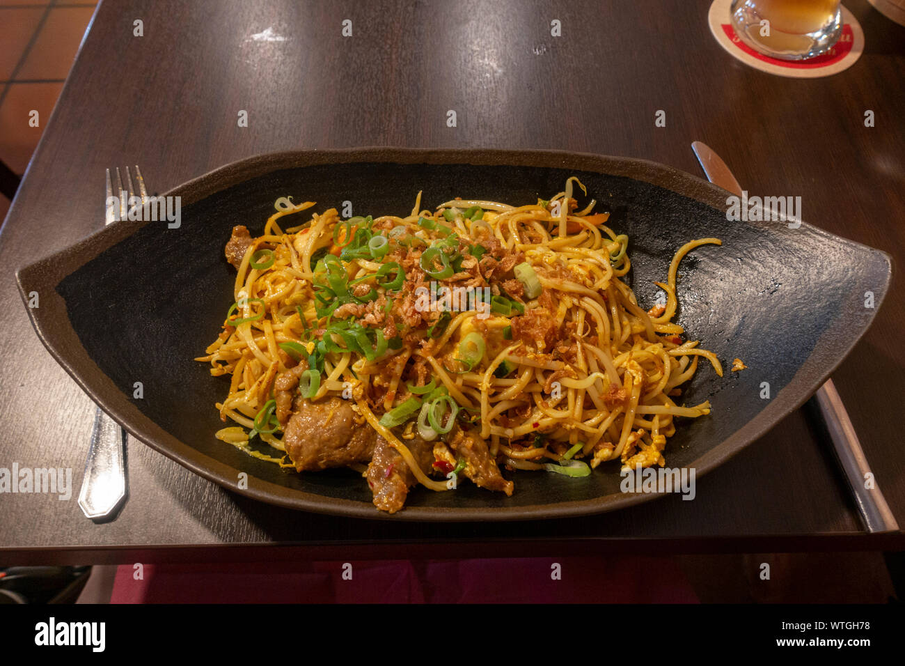 Un bami goreng (nouilles au boeuf, poulet), un plat indonésien, comme proposé dans un Munich, Bavière, Allemagne restaurant cuisine asiatique. Banque D'Images