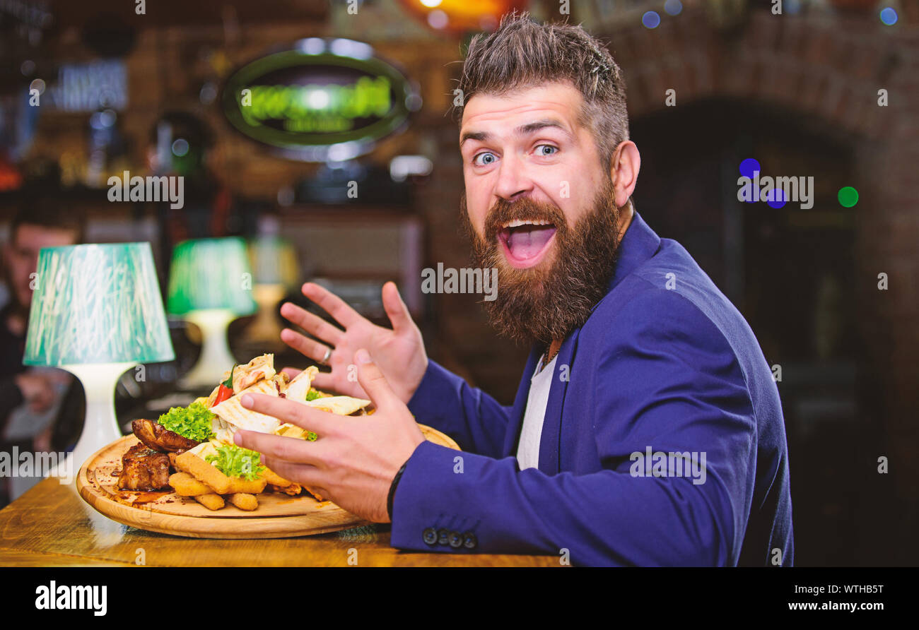 Woman costume formel s'asseoir à comptoir bar. L'homme a reçu de pommes de terre frites repas avec viande et poisson, lavash. Il méritent de délicieux repas. Profitez de repas. Des calories. Vous pourrez vous détendre après une dure journée de travail. Banque D'Images