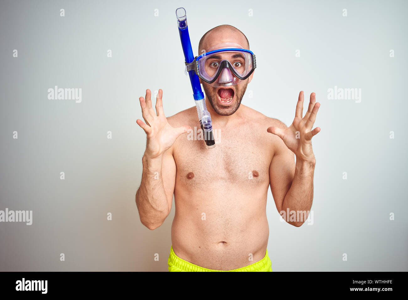 Jeune homme portant des lunettes de plongée tuba equipent sur fond isolé  célébrant la folie et étonné pour le succès avec les bras levés et les yeux  ouverts, la SCR Photo Stock -