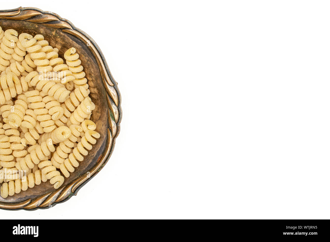 Beaucoup d'entiers et frais fusilli bucati pâtes crues copyspace dans de vieux bol de fer flatlay isolé sur fond blanc Banque D'Images