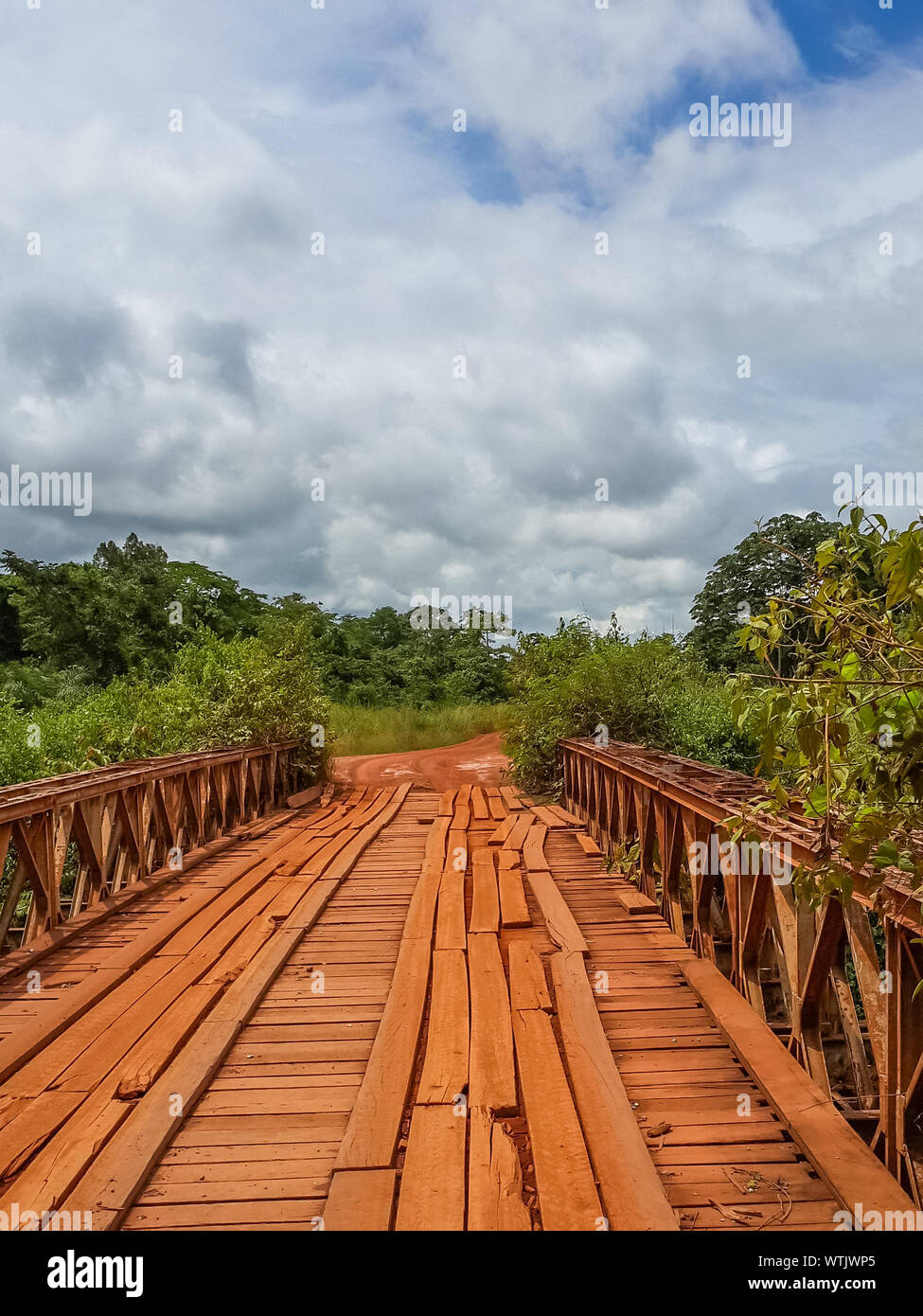 Pont en bois simple au milieu des arbres contre ciel nuageux en milieu rural au Gabon, l'Afrique Banque D'Images